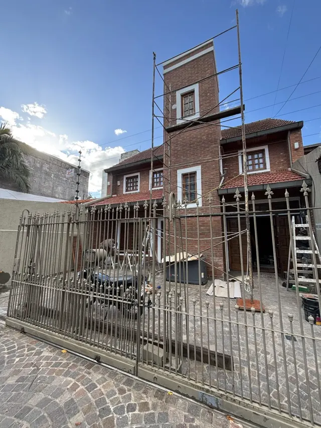 Andamio montado sobre el frente de ladrillo de una casa