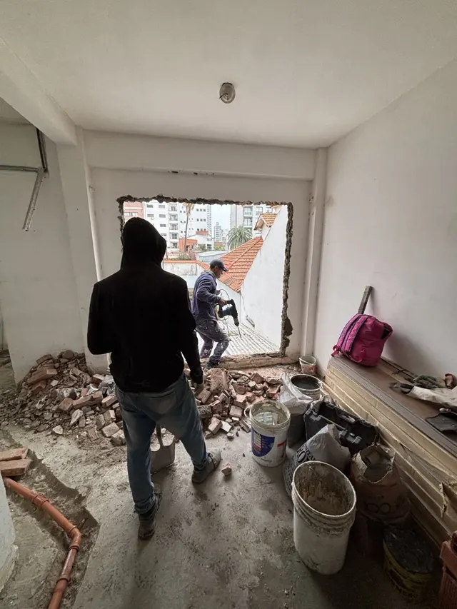 Dos operarios demoliendo una pared